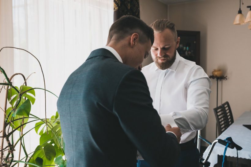 Świadek zapina spinki pana młodego