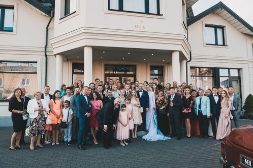 Zdjęcie grupowe na ślubie przed hotelem Mansor