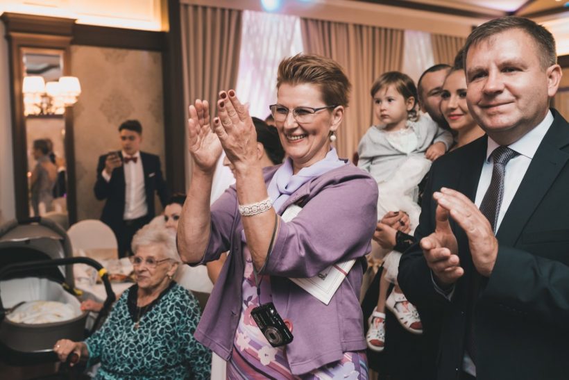 Kobieta w okularach klaszcze radośnie